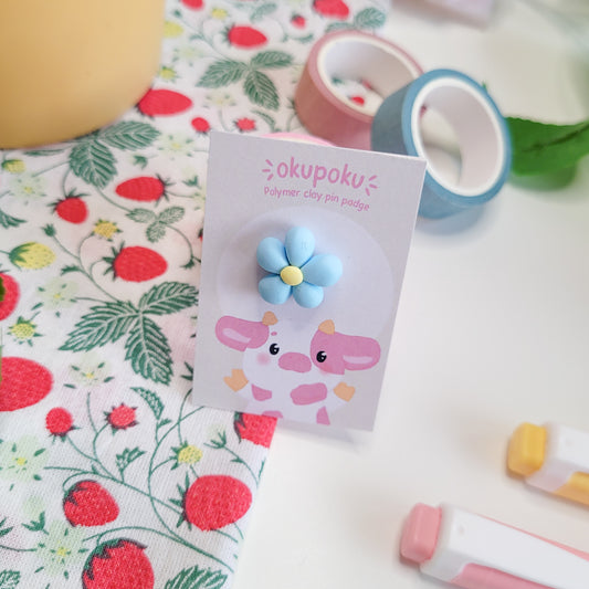 cute handmade blue daisy pin badge made out of polymer clay
