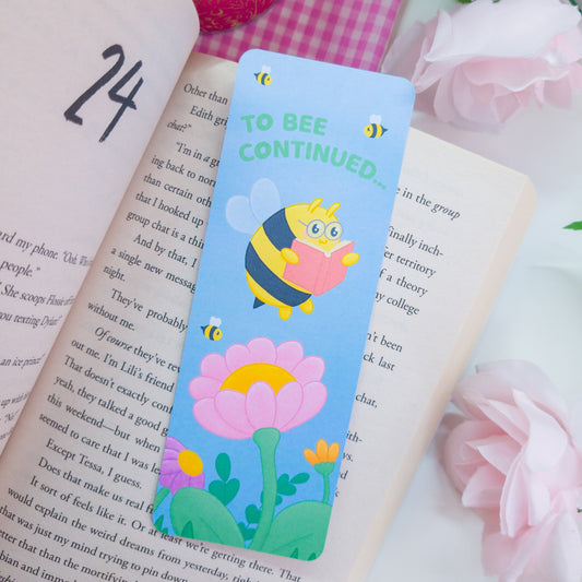 to bee continued bookmark featuring a bee reading among flowers